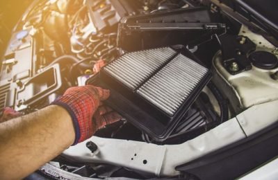 Car air filter in a hand of mechanic man is installing into air filter socket of car engine,Automotive part concept.